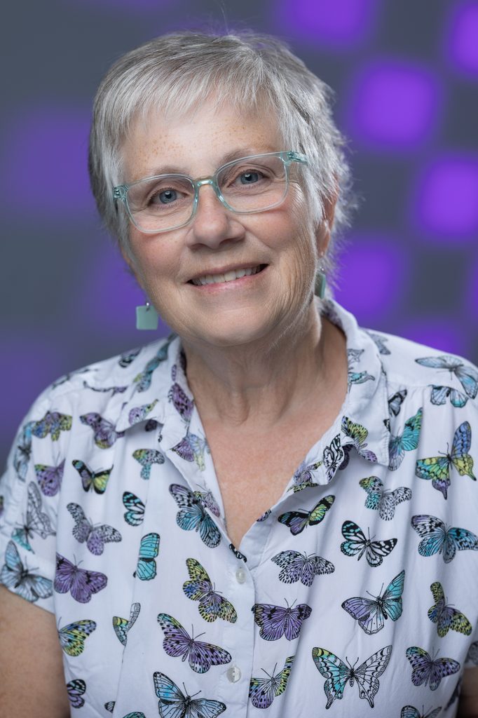 Soft, warm studio lighting and a confident expression give this professional headshot a welcoming, refined feel.